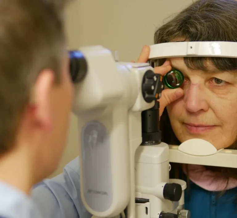Augenuntersuchung: Optiker nutzt eine Volklinse zur Untersuchung des Auges einer Patientin.