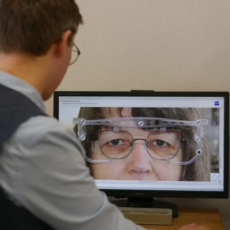 Person betrachtet eine Nahaufnahme von jemandes Gesicht auf einem Computerbildschirm.